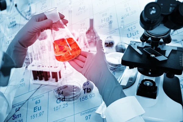 Close-up of clinician working with tools during scientific experiment in laboratory with chemical table background.