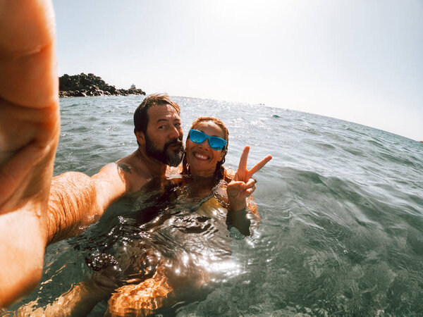 Cheerful adult couple take selfie picture swiming at the sea and enjoying summer holiday vacation together