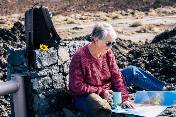 积极的老年退休生活 与美丽而成熟的高加索女人一起坐在户外旅行背包里 选择度假和休闲活动 在地图上规划目的地 — 图库照片