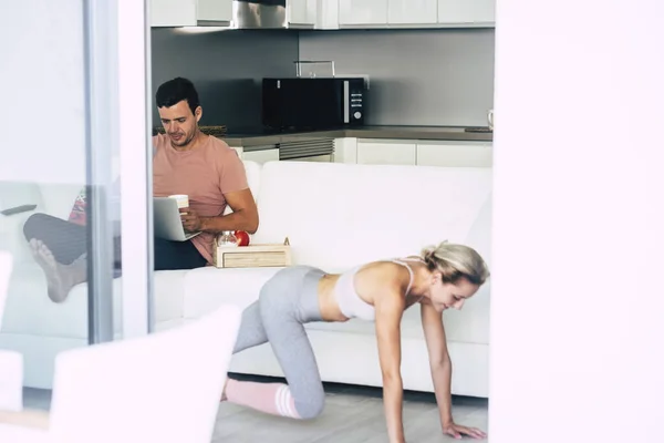 这对年轻夫妇在家上网用电脑锻炼身体 — 图库照片