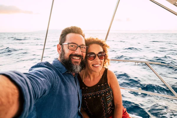 快乐的人们快乐的成年夫妇拍下了自己的照片 一起享受暑假假期 与大海和天空为背景的船同行 — 图库照片
