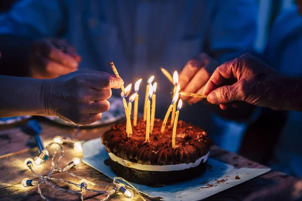 Close Van Mensen Handen Vuur Kaarsen Een Verjaardag Taart Tafel — Stockfoto