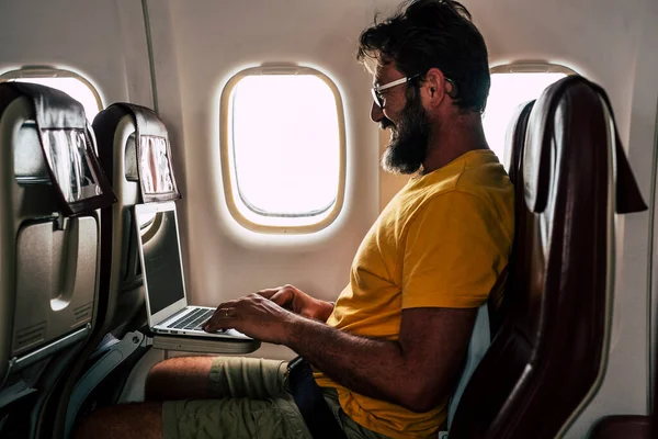 Hipstermann Med Skjegg Bærbar Datamaskin Som Sitter Bord Flyet Reisen – stockfoto