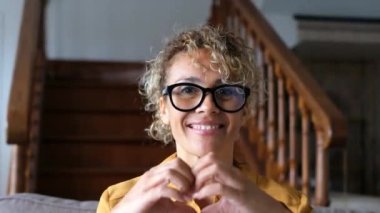 Güzel yetişkin bir kadın çevrimiçi içeriği kaydetmek için telefonun önünde konuşuyor.