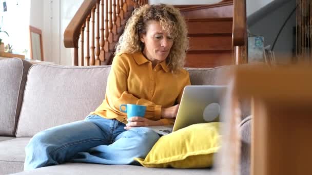 Mulher Loira Alegre Segurando Cur Usando Laptop Prata Enquanto Sentado — Vídeo de Stock