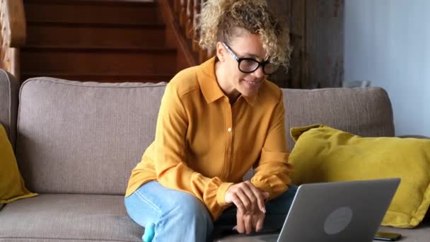 Mulher Loira Alegre Usando Laptop Prata Enquanto Sentado Sofá Sala — Vídeo de Stock