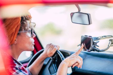 Dişi insanlar seyahat etmek ve varış noktalarına ulaşmak için arabanın içinde cep telefonu uydu haritası navigatörü kurdular. 