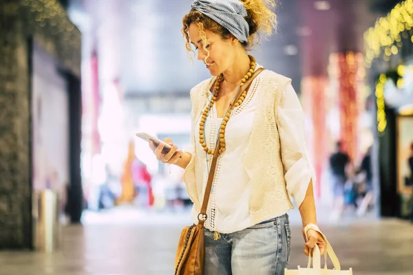 People use phone cellular in commercial center, cheerful pretty adult woman texting on smart phone during shopping activity