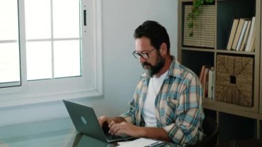 İş adamı evde dizüstü bilgisayarla çalışıyor.