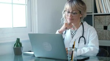 Kadın doktor evde dizüstü bilgisayarla çalışıyor, koronavirüs konsepti.