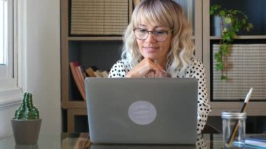 İş kadını evde dizüstü bilgisayarda çalışıyor.