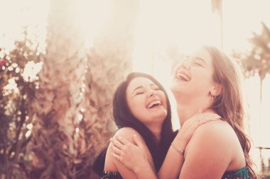 Couple of young woman have fun together hugging and laughing a lot in friendship or relationship clipart