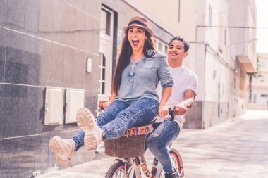 İnsanlar, eğlence ve yaşam tarzı konsepti. Şehirde bisiklet süren mutlu genç çift.
