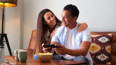 Mutlu çift evde telefonuyla hayatın tadını çıkarıyor.