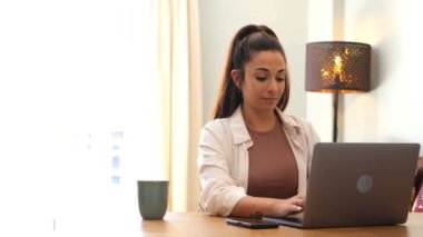 Ev işyerinde dizüstü bilgisayarla çalışan modern iş kadını 