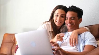 İki kişinin portresi bilgisayarla ve dizüstü bilgisayarla bağlantının keyfini çıkarıyor ve gülümseyip bilgisayarı izliyor.