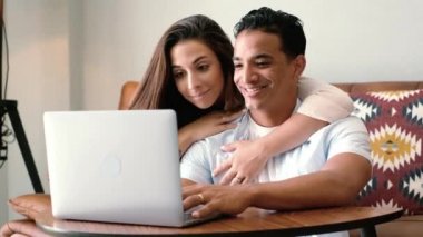 İki kişinin portresi bilgisayarla ve dizüstü bilgisayarla bağlantının keyfini çıkarıyor ve gülümseyip bilgisayarı izliyor.