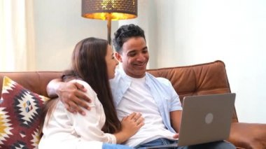 İki kişinin portresi bilgisayarla ve dizüstü bilgisayarla bağlantının keyfini çıkarıyor ve gülümseyip bilgisayarı izliyor.