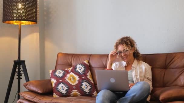 快乐漂亮的成年女子坐在沙发上 在网上做视频通话 — 图库视频影像