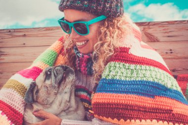 Yetişkin kadın ve pug köpeğinin birbirlerine sarılıp sarıldıkları mutluluk ve şefkat.