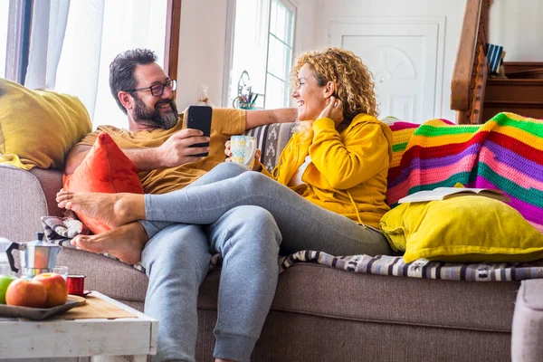 Lykkelig Voksen Par Derhjemme Sidder Sofaen Med Farverigt Cover Nyde - Stock-foto