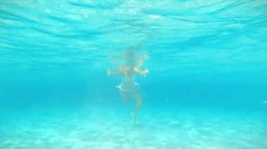 Arka planda havuzda yüzen genç bir kadın