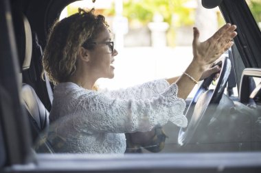 Arabayı kullanırken sinirli bir kadın bağırıyor. Stresli kadın trafikte araba sürüyor