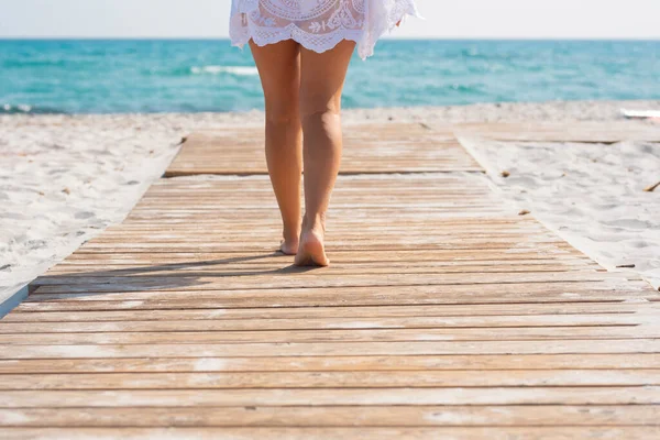 Low Section Woman Walking Wooden Plank Amidst Sand Leading Sea — Stock Photo, Image