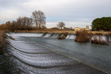 Manzara, nehir üzerindeki bir barajın taşma manzarası.