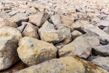 Various irregularly shaped, compacted stones as the basis for future asphalt pavement