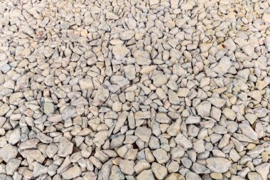 Various irregularly shaped, compacted stones as the basis for future asphalt pavement