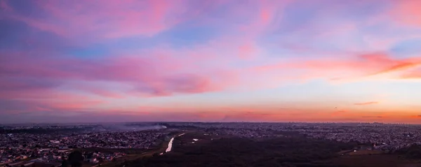 空中无人机图像日落与香草的天空和乌云与粉红色和紫色的颜色 在整个城市的底部 — 图库照片