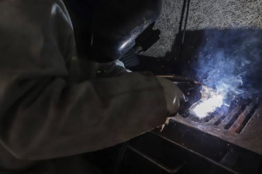 İşten gelen kıvılcımlar ve ışık. Resimde, işçinin ellerini ve profesyonel maskesini görmek mümkündür.