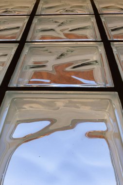 Çeşitli renklerde soyut ışıklandırmalı cam tuğlalar ve çarpık resimli yansıma