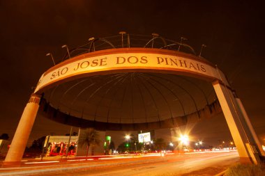 Curitiba 'nın Metropolitan Bölgesi' nde bulunan Avenida das Torres 'teki So Jos dos Pinhais giriş kapısından gelen ışık izleriyle düşük hızlı gece fotoğrafı.