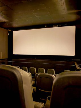 Görüntü, aynı zamanda film projeksiyon odası olarak da bilinen bir sinema salonunun içini gösteriyor. Seyirciler için koltukları ve ön tarafında büyük bir ekranı var..