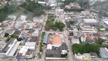Paran 'daki Cerro Azul şehrinin havadan görünüşü, bir vadide, bir ana caddesi, bir meydanı, binaları ve bir kilisesi var. Sahne ağaçlık dağlarla çevrili ve yoğun bir sisle kaplı..