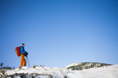 Dağcı kar yamaçta gider.
