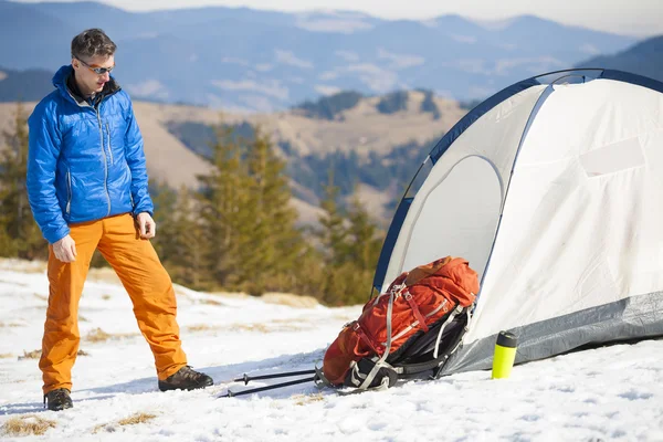 Bir turist bir çadır ve bir sırt çantası duruyor.
