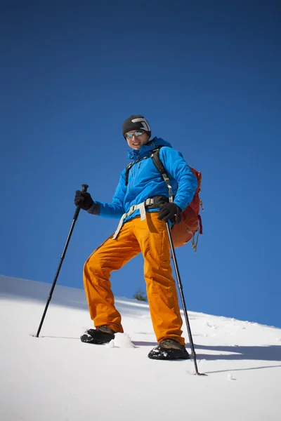 Arrampicatore con uno zaino sale sulla neve . — Foto Stock