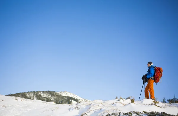 De klimmer gaat op de helling van de sneeuw. — Stockfoto