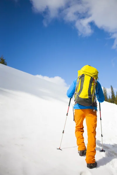 Bergsteiger mit Rucksack erklimmt den Schnee. — Stockfoto