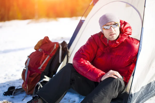 Klimmer met een rugzak in de buurt van de tent. — Stockfoto