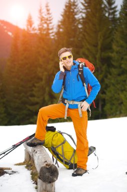 Adam telefonda konuşurken bir sırt çantası ile.