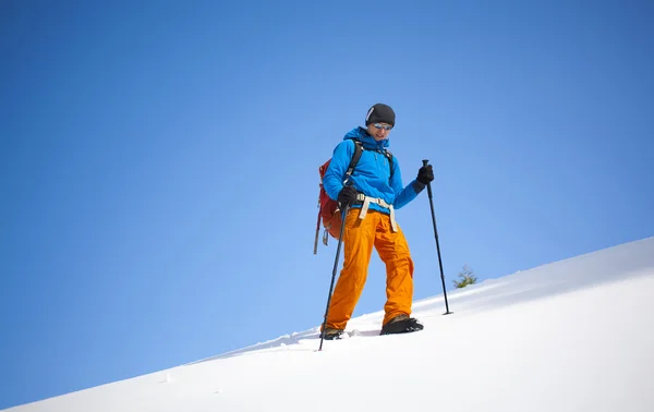 Der Bergsteiger geht auf den Schneehang. — Stockfoto