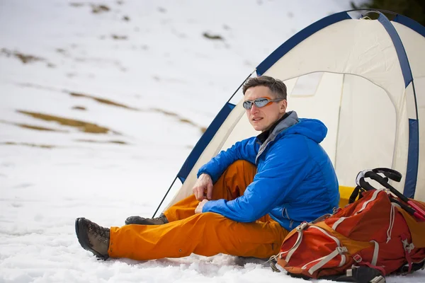 Ein Tourist steht neben einem Zelt und einem Rucksack. — Stockfoto