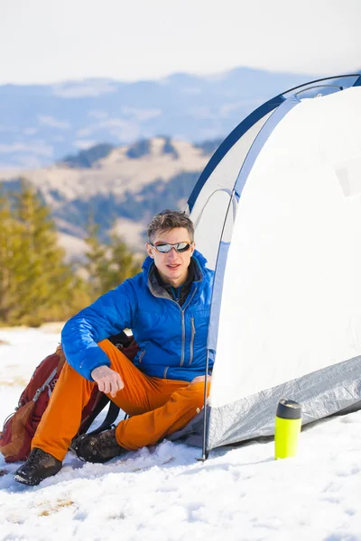 En turist står nära ett tält och en ryggsäck. — Stockfoto