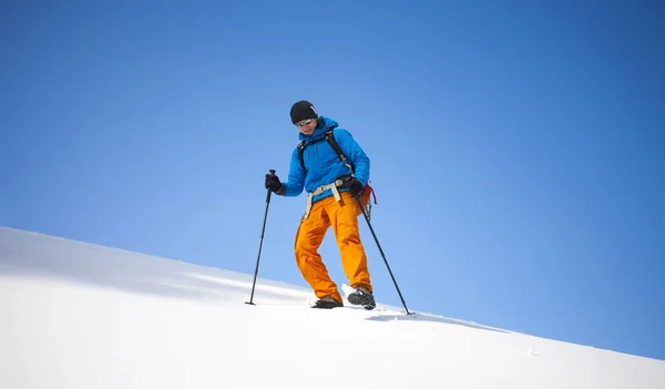 Der Bergsteiger geht auf den Schneehang. — Stockfoto