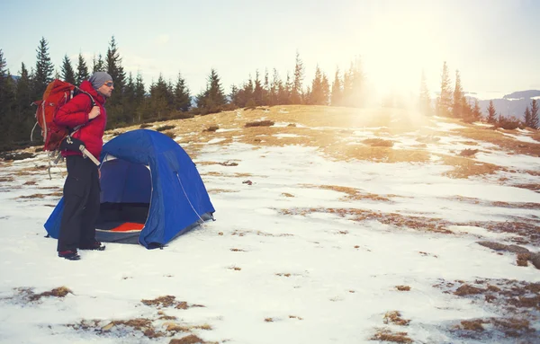 Um alpinista com uma mochila perto da tenda . — Fotografia de Stock