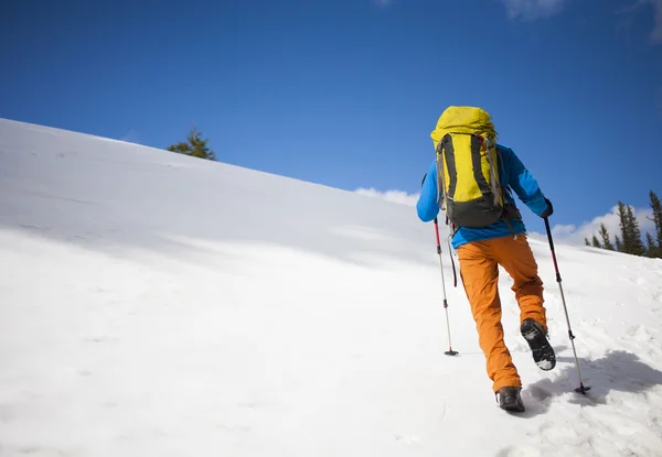 Escalade avec un sac à dos grimpe la neige . — Photo